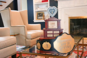 Image of Founders Day of Giving Belt and Trophy on a coffee table.